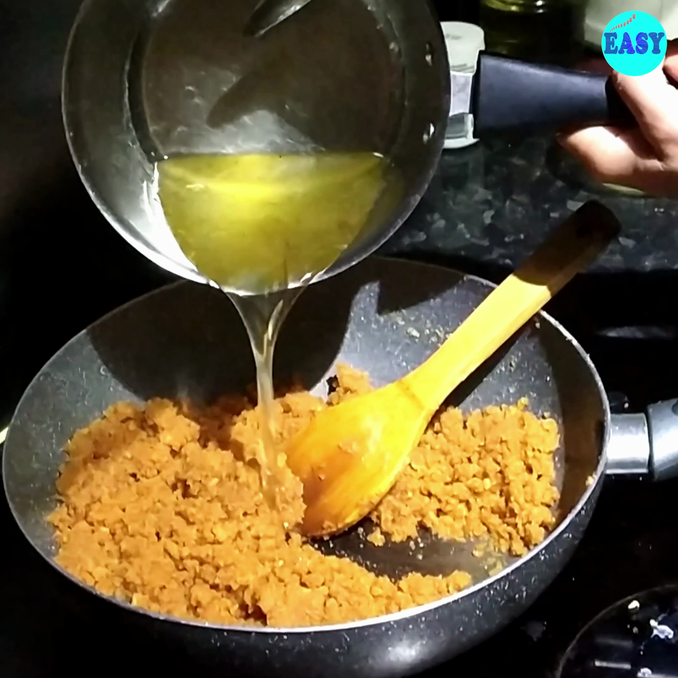 Step 9 - Once the milk is absorbed add the warm sugar syrup to the dal mixture. Stir well to combine the dal paste with the sugar syrup.