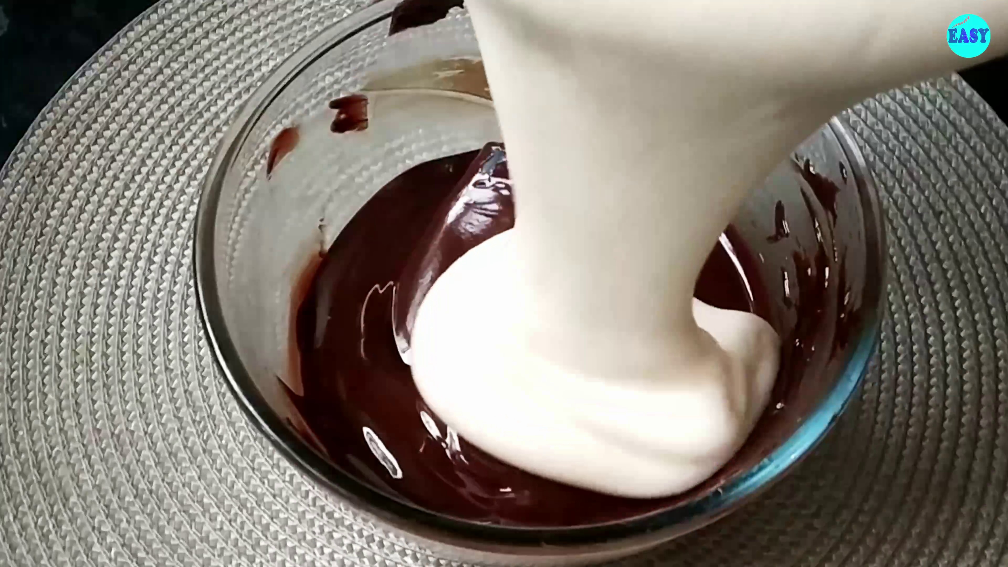 Step 7 - Now add some of the egg mixture to the chocolate mix that we melted earlier. Mix it gently without deflating the eggs. It will help to lighten up the chocolate mixture, so once we add it to the remaining eggs it will be easier to mix.
