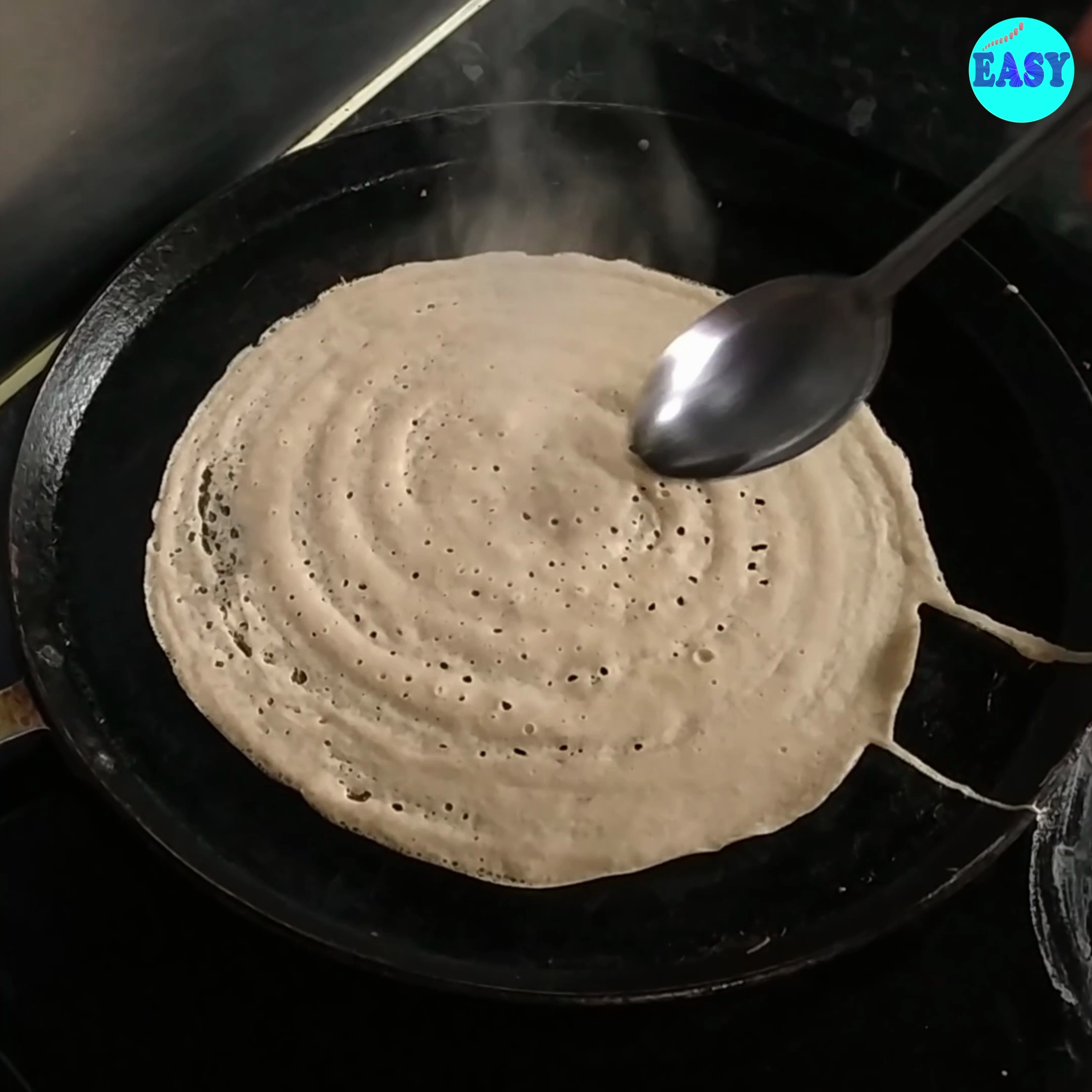 Step 8 - 8. Drizzle some ghee or oil around the edges and on top of the dosa. Cook for 2-3 minutes on medium heat until the edges lift and the bottom turns golden brown.