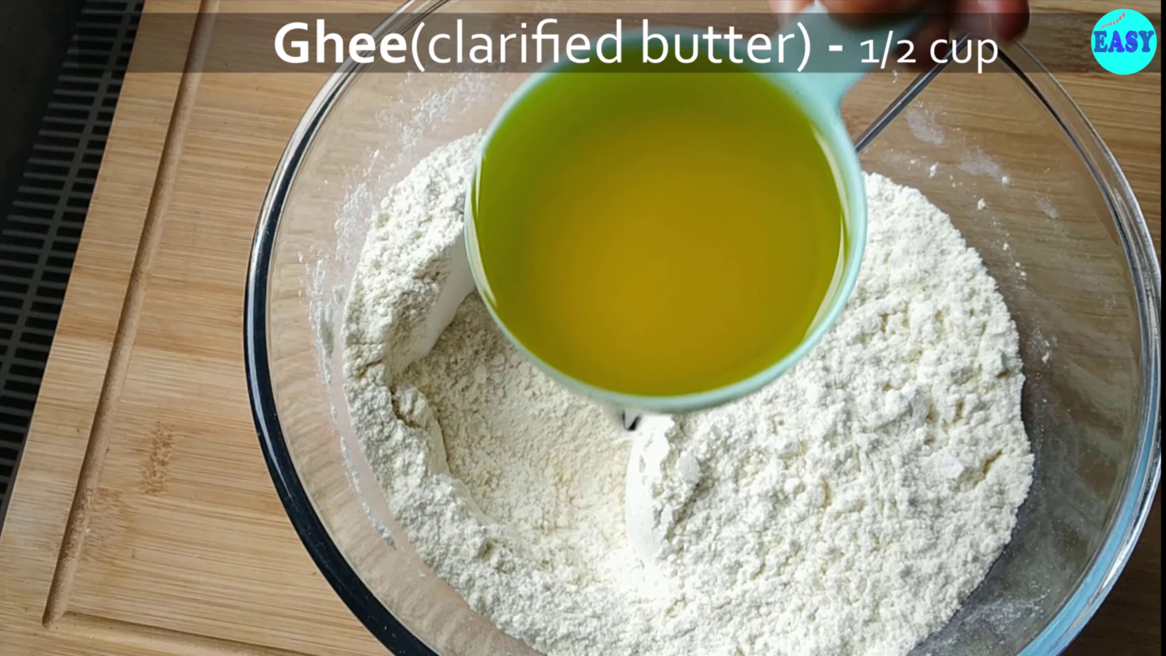 Step 3 - Add the ghee (clarified butter) to the flour mix and begin to mix with a spoon or spatula. Until its well blended.