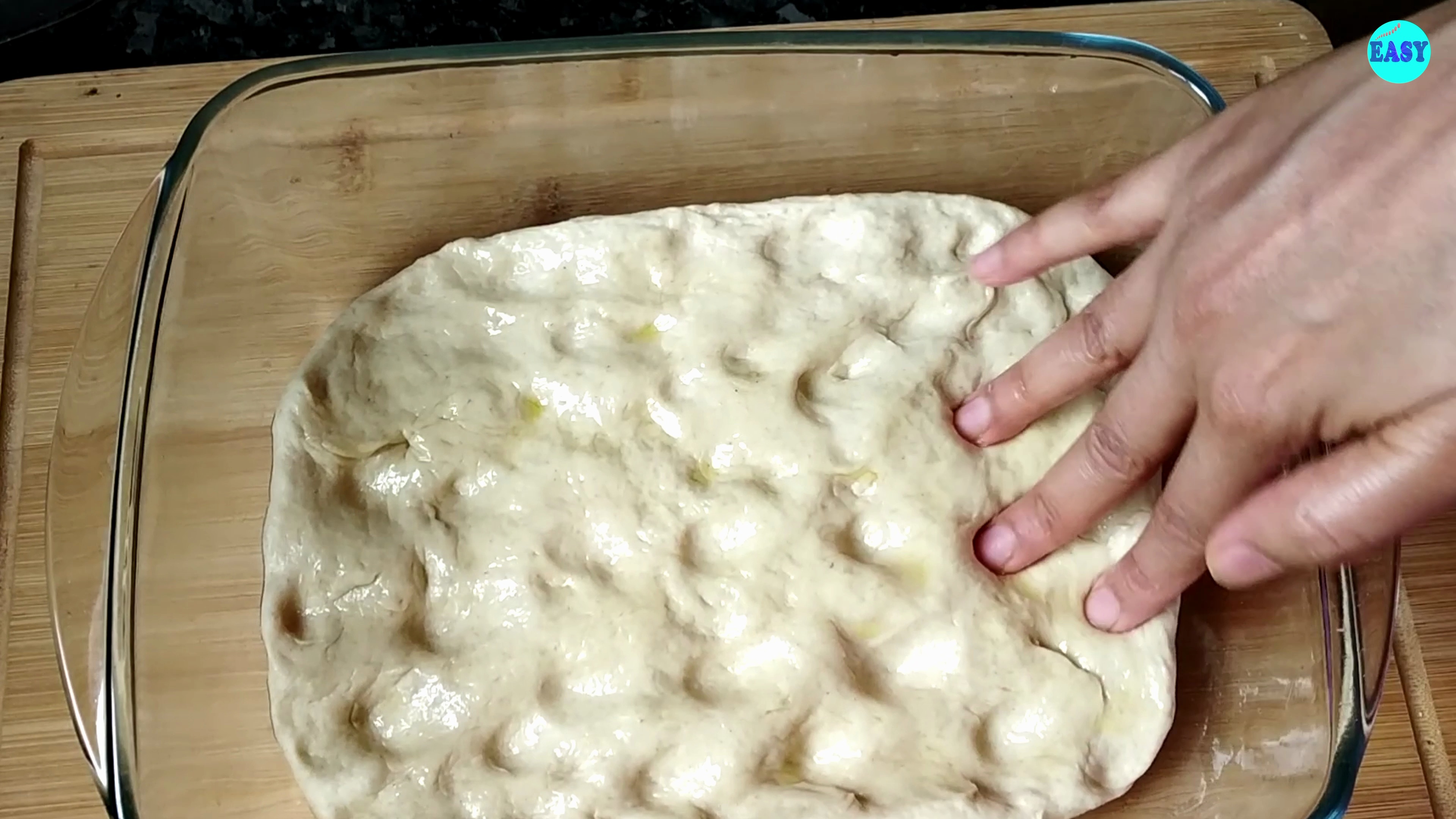 Step 6 - Punch down the dough and transfer it to a greased baking sheet. Use your fingers to press the dough into a flat, rectangular shape.